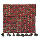 Under the Mistletoe table runner showing deep red print and decorative tassels against a white background.