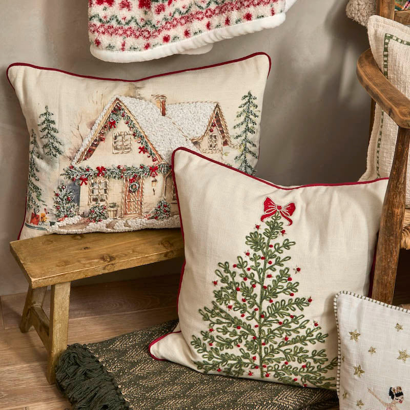 Festive cotton cushion with embroidered tree design styled in a cozy room setting with seasonal decorations.