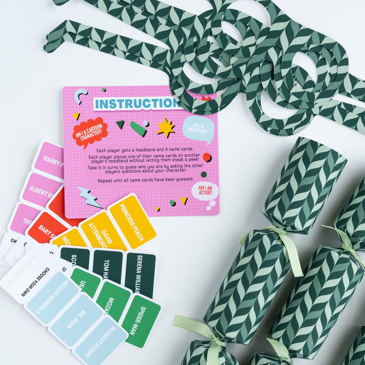 Close-up of cracker contents including name cards, instruction sheet, and green patterned glasses.