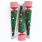 Close up of three upright Christmas tree crackers showing the festive green patterns and red striped bases.