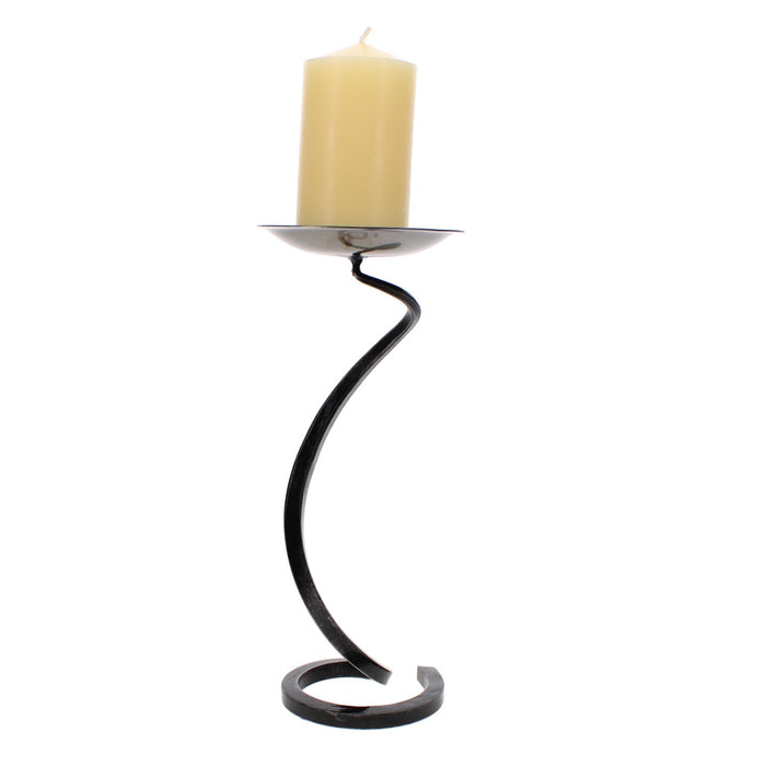 Hand-forged black iron candlestick with a cream pillar candle on a simple round dish top.