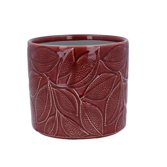 Deep red ceramic plant pot with embossed leaf pattern on a white background