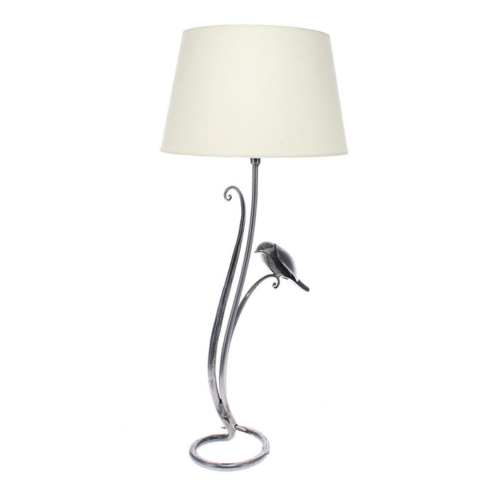 Hand-forged iron Bird Lamp with a cream shade, featuring a sculptural bird detail on the stem.