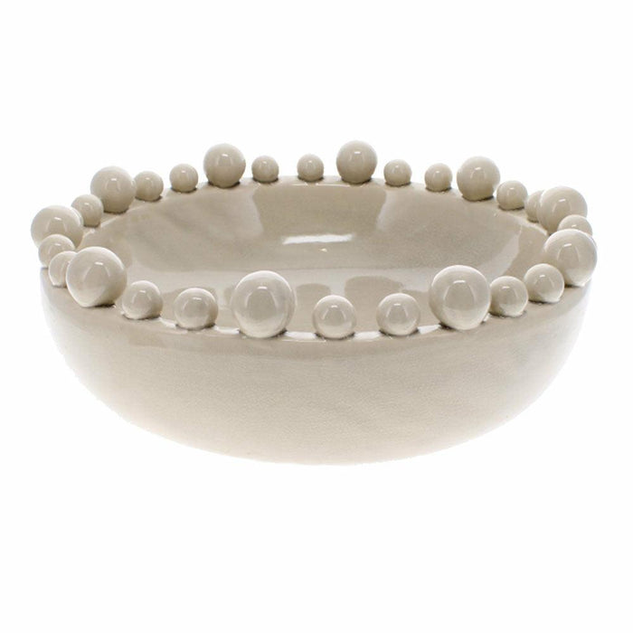 Creamy taupe ceramic bobble bowl with variable sized spheres along the rim against a white background