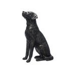 A bronze resin sculpture of a sitting labrador looking upwards, showing detailed textured fur and finish.