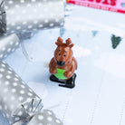 Close-up of a brown wind-up reindeer character on a winter-themed race track