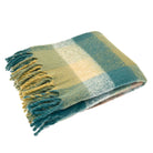 Folded faux mohair check throw showing teal, green, and beige squares with tassel fringe.