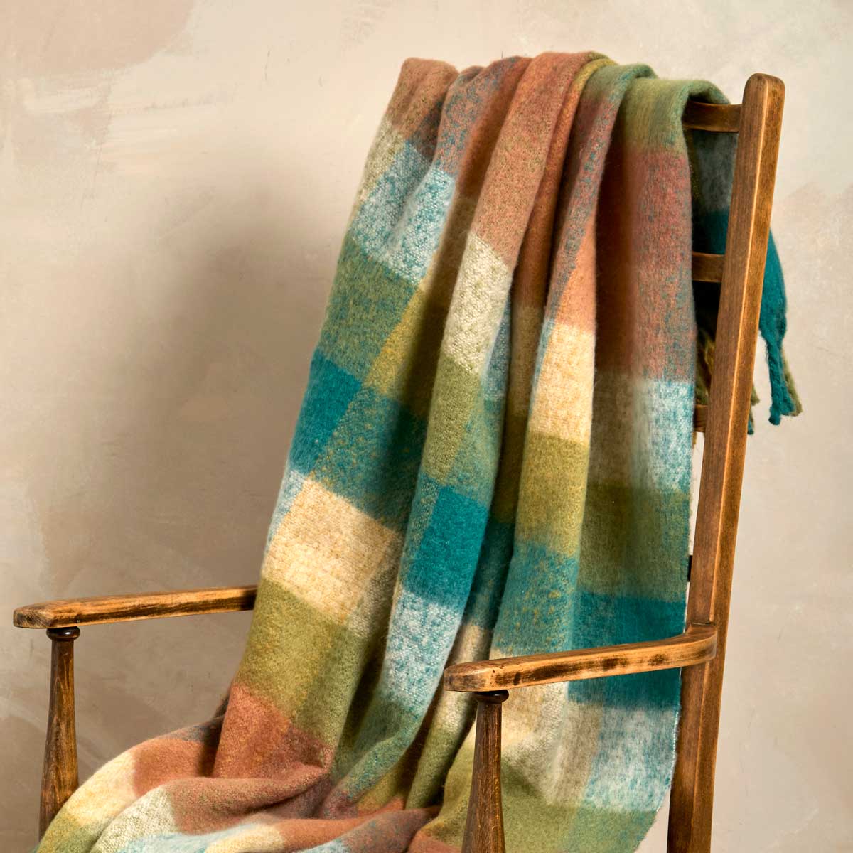 Faux mohair check throw draped over a wooden chair, showing the soft texture and large check pattern.