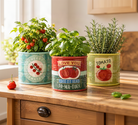 Ceramic tomato pots styled on a wooden kitchen counter holding fresh basil, rosemary, and tomato plants.