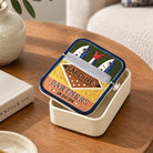 Ceramic sardine pot with lid styled on a wooden side table next to a book, showing its decorative scale.