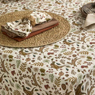 Woodland print napkins styled on a rustic place setting with a matching tablecloth and woven placemat.
