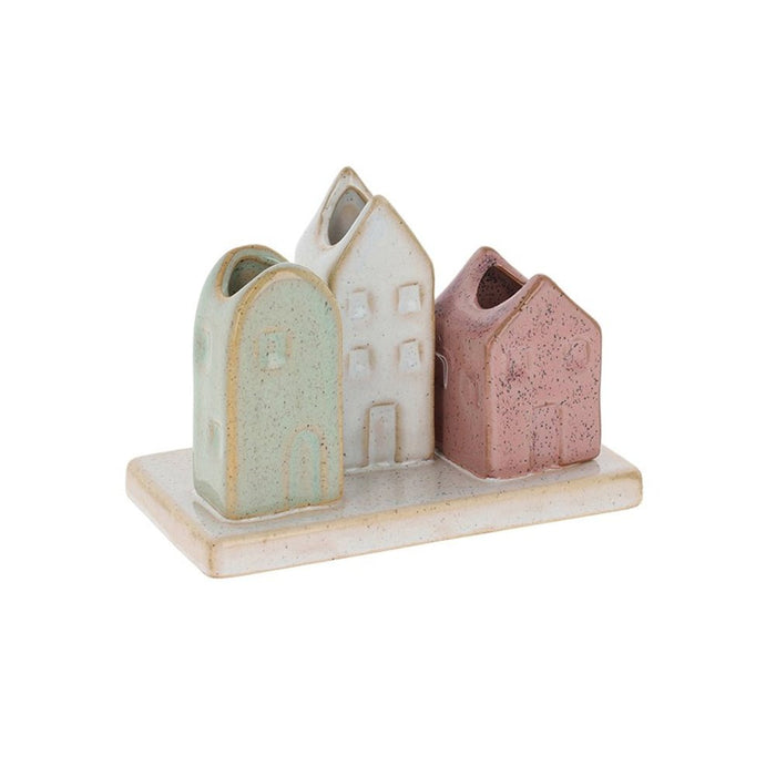 Three pottery house-shaped stem vases in mint, white and blush pink with a speckled glaze on a ceramic base.