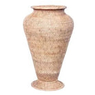 Tapered natural rattan pot with a pedestal base and wide rim against a white background.