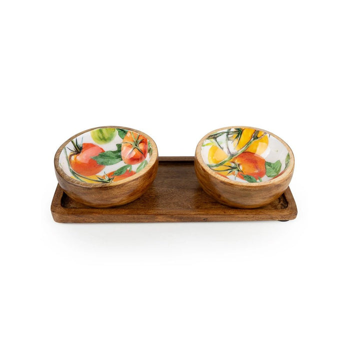 Two mango wood dipping bowls with tomato designs inside, sitting on a dark wooden tray
