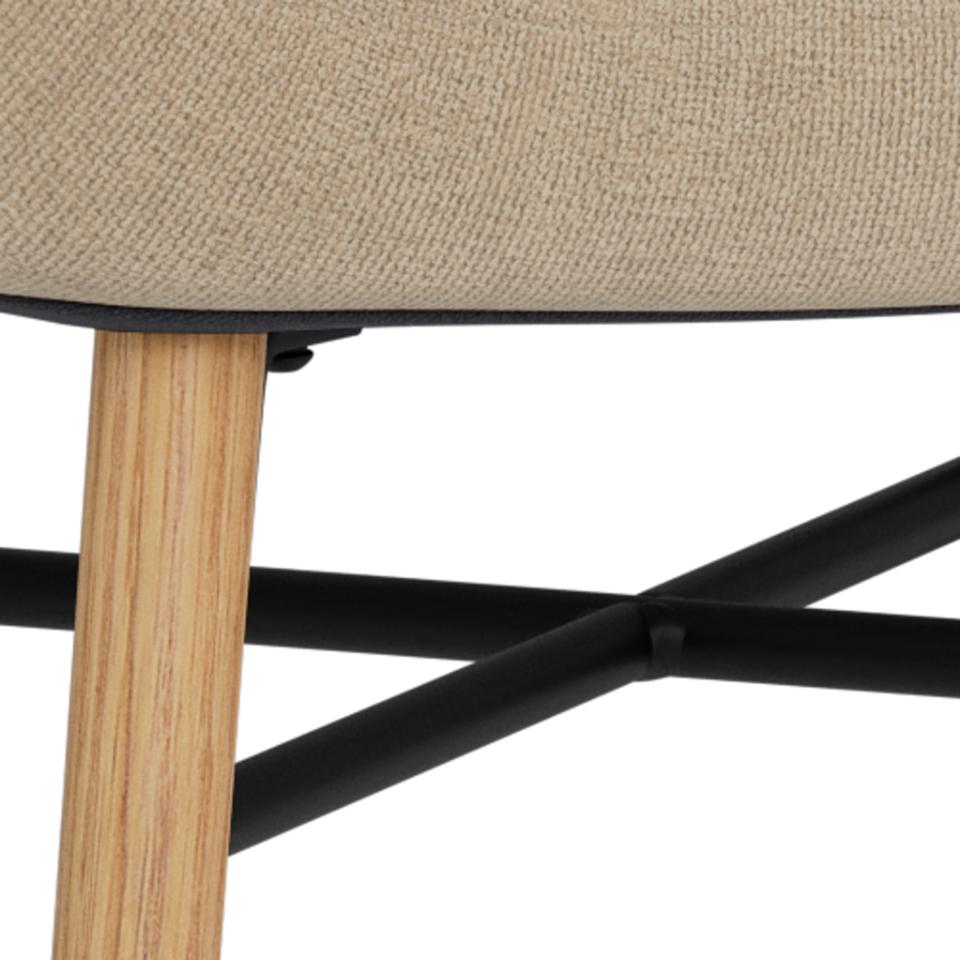 Close-up of the oak chair leg and black metal cross-frame support