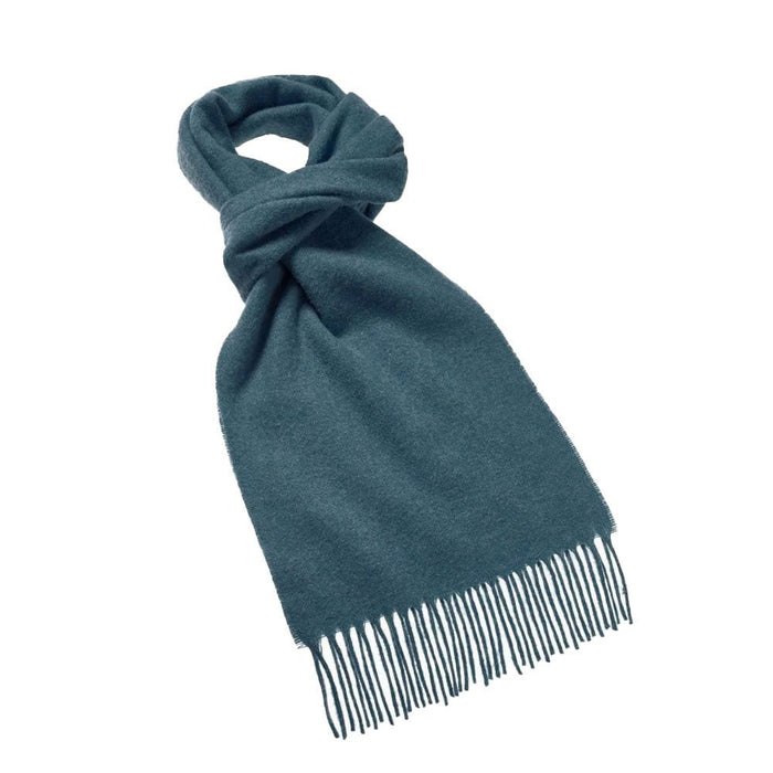 Teal Merino wool scarf with fringed edges neatly knotted on a white background