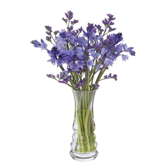 Small clear glass Wibble Vase filled with a vibrant bouquet of purple and blue flowers.