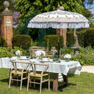 The Bali sun parasol providing shade over a dressed outdoor dining table in a sunlit English country garden.