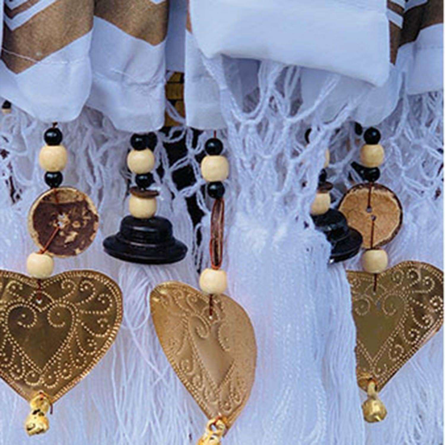 Close-up of the parasol fringe featuring white tassels, black beads, and gold hammered heart-shaped pendants.