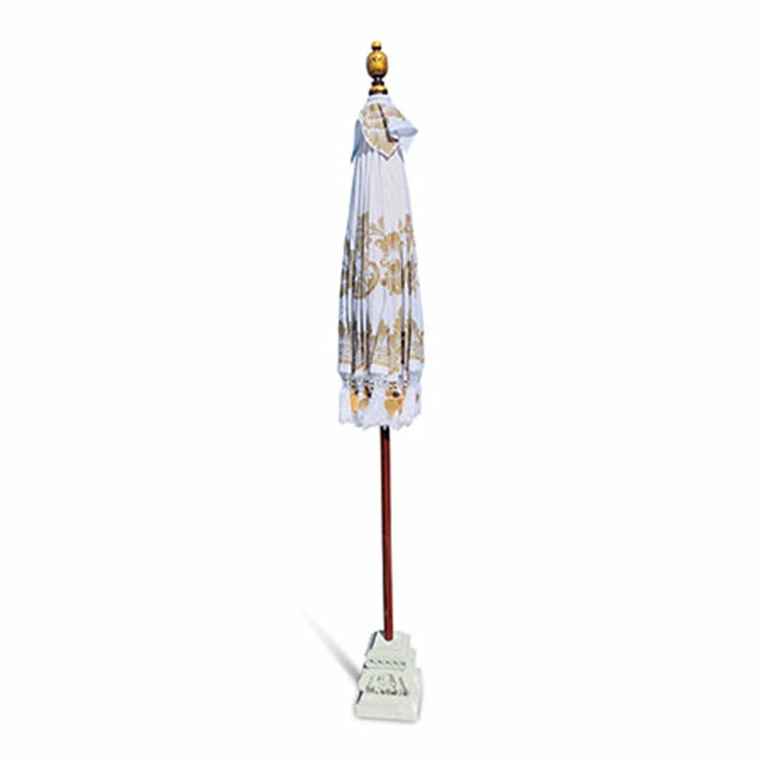 Closed white and gold Balinese parasol showing the folded fabric and carved decorative top finial.