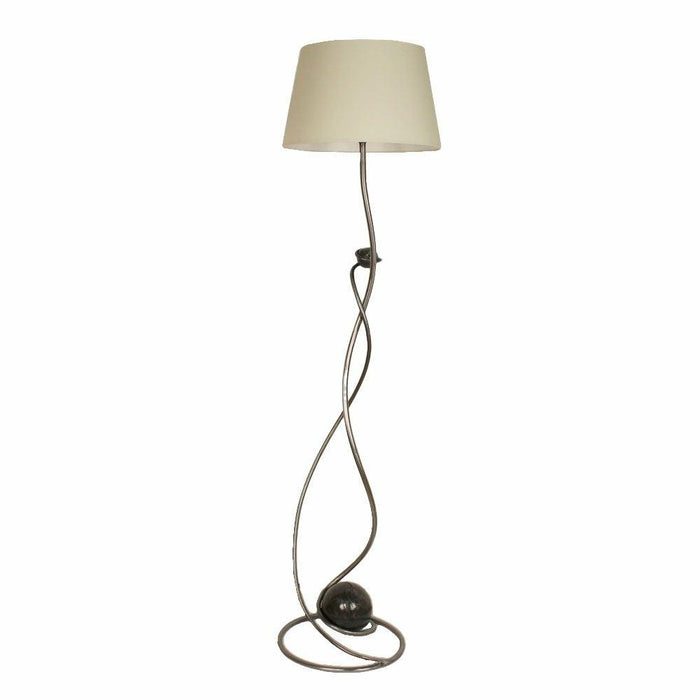 Hand-forged wrought iron floor lamp with a twisting stem and a simple cream shade.