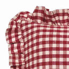 Close-up of the red gingham linen fabric showing the frayed edge detail and ruffle.