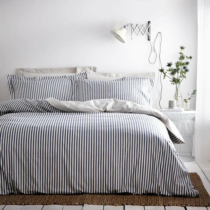 Navy and white mélange stripe duvet cover and pillowcases on a bed in a bright, modern room