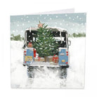 Jolly Journey Christmas card featuring a blue Land Rover in the snow with a Christmas tree in the back.