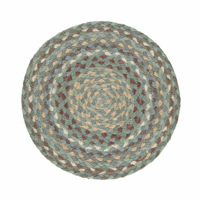 Round braided jute placemat showing concentric circles of blue, green, and cream sea-inspired colours.