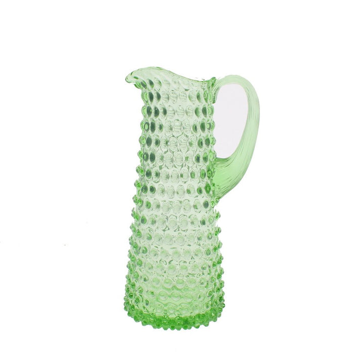 Tall slender spring green hobnail glass jug with clear textured handle against a white background